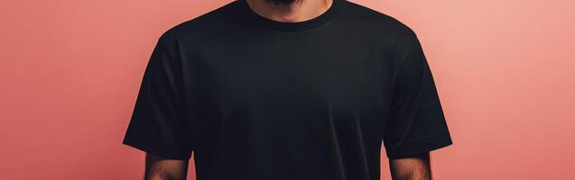 Man wearing plain black t-shirt against pink background photo