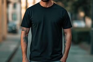 Man in black t-shirt poses casually on city street photo