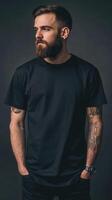 Man with tattoos poses in a studio against a dark backdrop photo