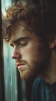 Lonely man reflecting by the window on a quiet evening photo
