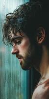 A man with wet hair standing by a window photo