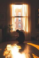 Person in silhouette kneeling on floor during sunset light photo