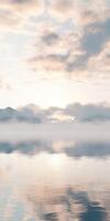 Misty morning in a tranquil landscape with mountains and lake photo