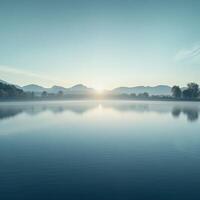 Morning fog envelops tranquil lake and mountains at dawn photo