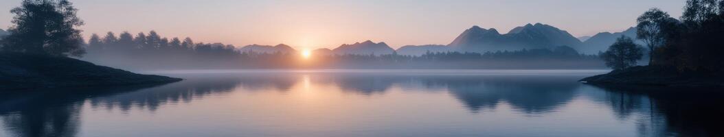 The sun rises over a lake in the mountains photo