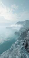 Misty coastline with fog enveloping rocky cliffs and serene water photo