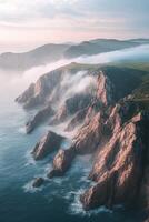 Fog envelops rocky coastline at dawn in serene natural landscape photo