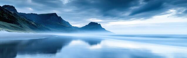 Fog envelops tranquil coastline revealing distant mountains photo