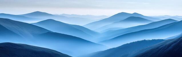 Expansive blue mountains shrouded in fog during early morning hours photo