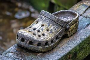 Wooden clog placed on a rustic wooden plank near a waterway photo