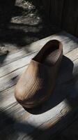 Clogs resting on a rustic wooden surface with natural shadows photo
