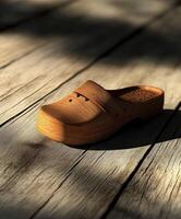 Wooden clogs resting on a rustic wooden surface in soft lighting photo