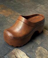 Beautiful wooden clogs displayed on a textured stone surface photo