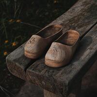 Wooden clogs resting on a rustic wooden bench in nature photo