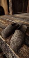 Clogs made from weathered wood on rustic wooden surface photo