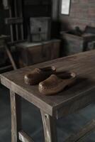 Clogs placed on a rustic wooden table in a traditional workshop photo