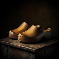 Unique wooden clogs resting on a rustic wooden surface in dim light photo