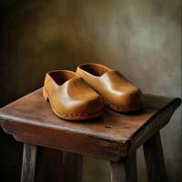 Classic wooden clogs displayed on a rustic stool in soft light photo