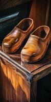 Handcrafted wooden clogs displayed on a rustic wooden surface photo