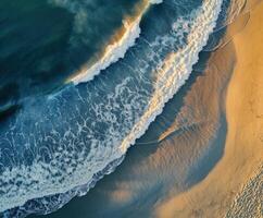 Waves gently lapping at the sandy shoreline during sunset photo