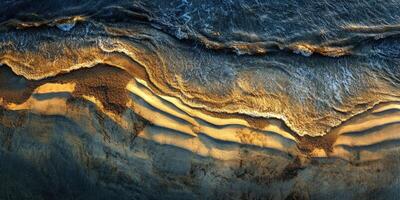 Waves crashing on a sandy shoreline at sunset photo