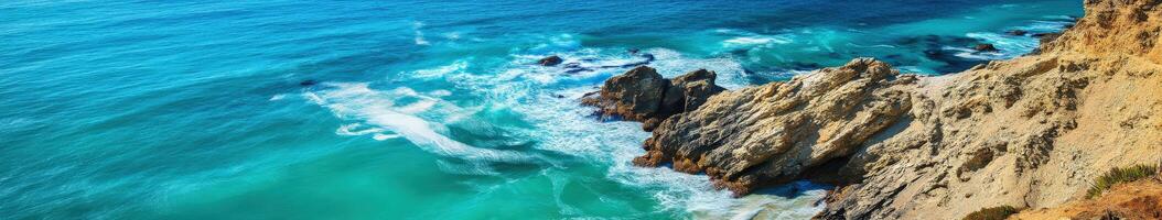 A rocky cliff with waves crashing into the ocean photo
