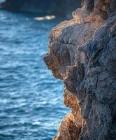 A rock face on the edge of the ocean photo