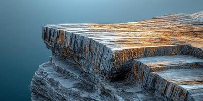 A large rock formation on the edge of the ocean photo