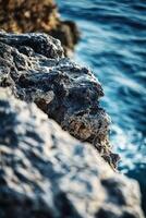 A rock formation on the edge of the ocean photo