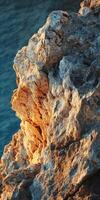 A rock formation on the edge of the ocean photo