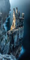 A rocky cliff with a lighthouse on top photo