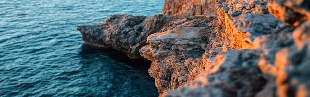 A rocky cliff with the ocean in the background photo