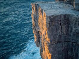 Sunlight on rugged cliff edge photo
