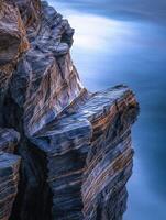 A rock formation on the coast of the ocean photo