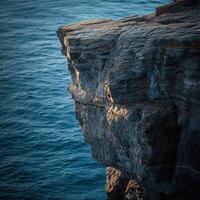Rugged cliff edge above ocean photo