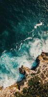 Rocky coast meets turquoise waves photo