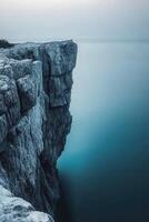 Rocky cliff over calm water photo