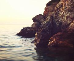Calm waters meet rocky shore photo