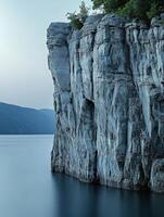 A large rock formation is in the middle of the water photo