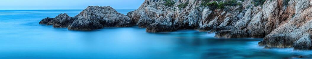 Rocky cliffs and blue water in the ocean photo