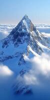 Snow-capped mountain peak above clouds photo