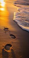 Footprints on the beach at sunset photo
