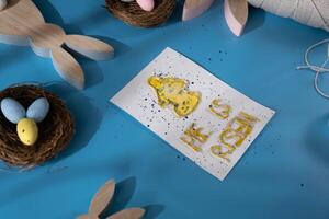 Handmade greeting card with message HE IS RISEN written in beautiful handwriting. Gesture shows excitement and joy for the upcoming event. Springtime holiday gift present zero cost ideas. Creative art preparation photo