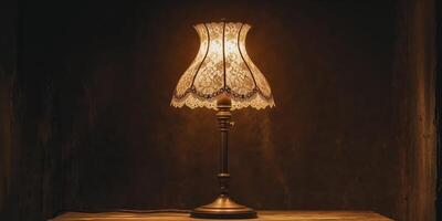 Classic Table Lamp with Lace Shade Illuminated Warmly in a Dark Setting photo