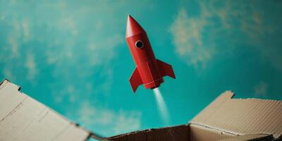 A red rocket is flying out of a cardboard box photo