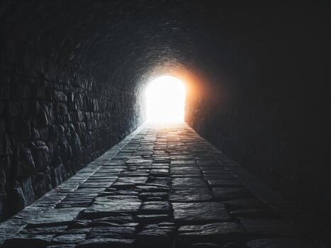 Dark tunnel with light at the end creating a sense of depth and perspective. photo