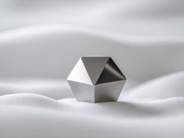 A silver object sitting on top of a white surface photo