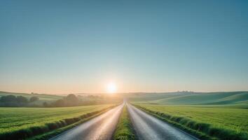 Sunlit Country Road Through Fields at Dawn with Clear Sky and Open Space for Text or Branding. photo