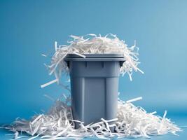 Gray trash bin overflowing with shredded paper on a blue background photo