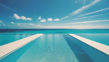 A pool with a blue sky and ocean in the background photo
